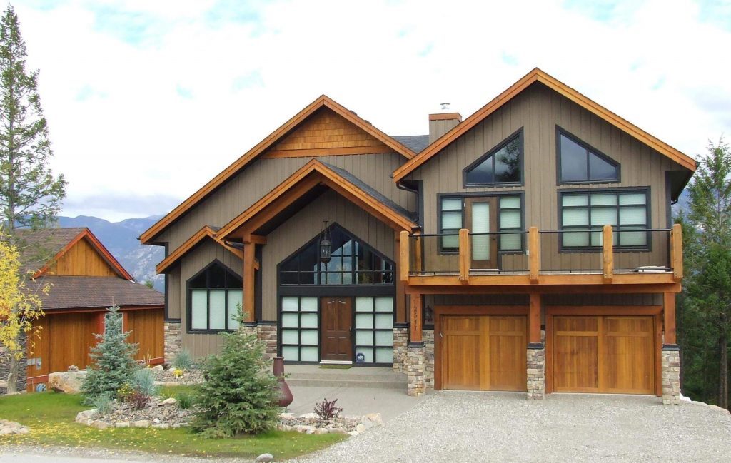 A timber home with a glass-fronted entry, a balcony and a double garage